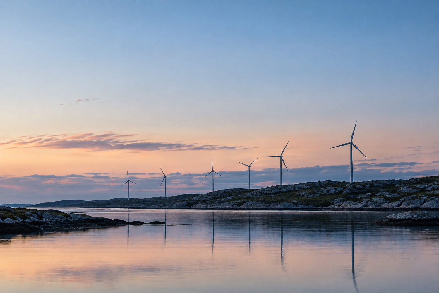 Vindkraftverk på en höjd vid havet i skymningen